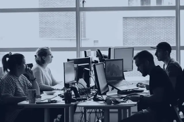 Colleagues working together at computer workstations in an open office